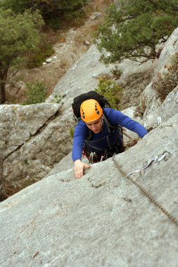 genç adam arka planda Vadi Manzaralı dikey duvar tırmanışı