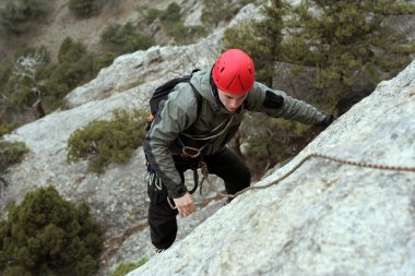 genç adam arka planda Vadi Manzaralı dikey duvar tırmanışı