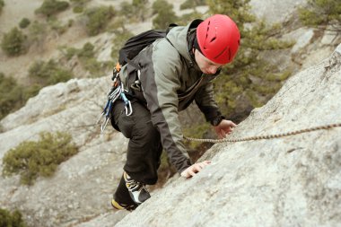 genç adam arka planda Vadi Manzaralı dikey duvar tırmanışı