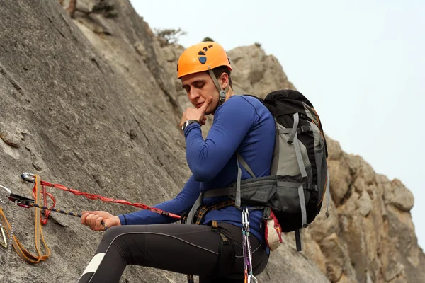 Jeune homme escalade mur vertical avec vue sur la vallée sur le fond — Photo