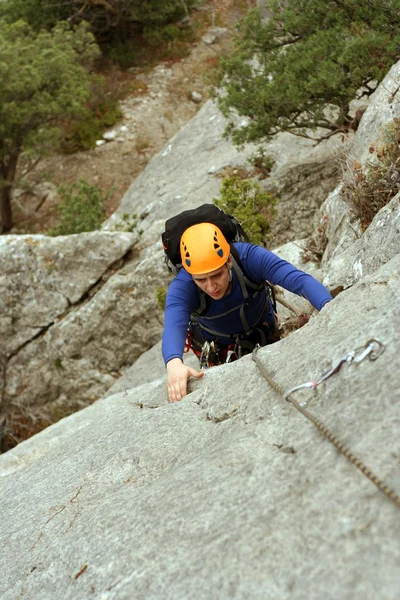 genç adam arka planda Vadi Manzaralı dikey duvar tırmanışı