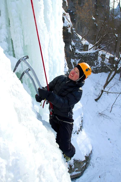 Homem escalando cascata congelada — Fotografia de Stock