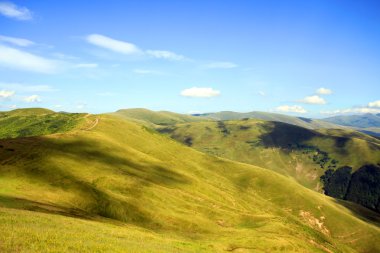 Yeşil çimenli, yollu ve bulutlu yaz manzarası