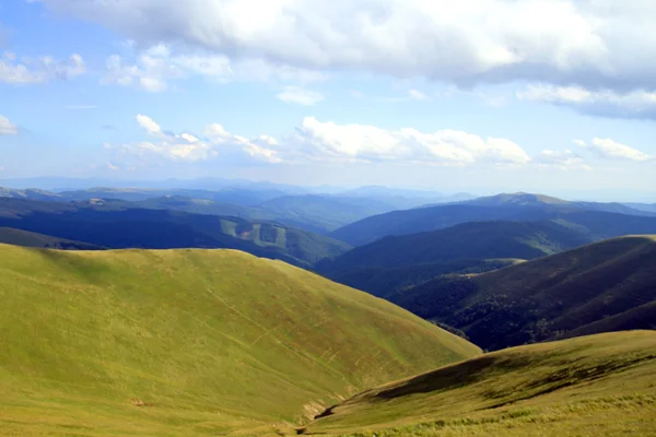 Paesaggio estivo con erba verde, strada e nuvole — Foto Stock