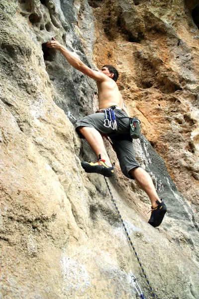 Rock climber climbing up a cliff — Stock Photo, Image