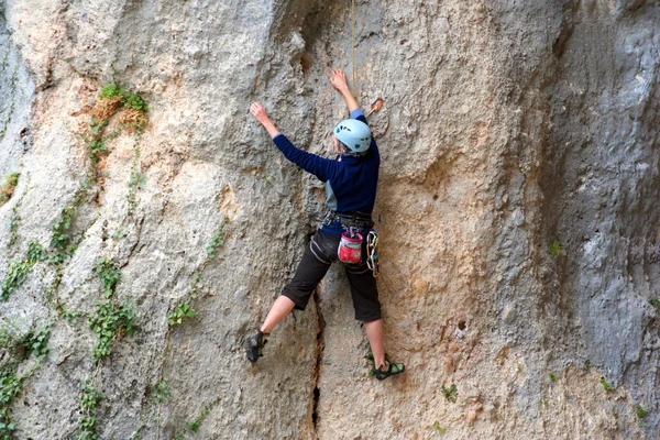 Rock climber climbing up a cliff — Stock Photo, Image