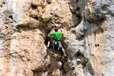 bir adam duvara tırmanıyor.