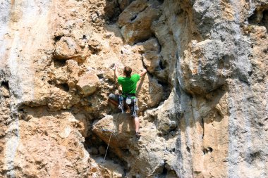 bir adam duvara tırmanıyor.
