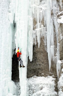Ice climber mücadeleler donmuş şelale yukarı.