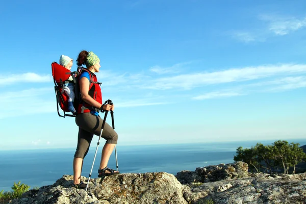 Madre con portabebés llevando a un hijo en los Alpes en un día soleado — Foto de Stock