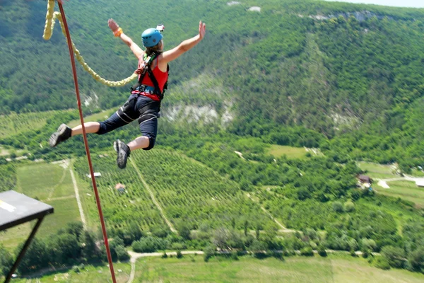 Mit einem Seil von einer Klippe springen. — Stockfoto