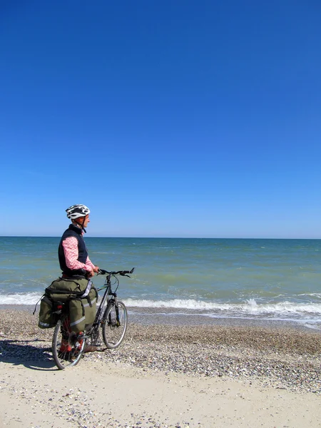 Man die op het strand met fiets. — Stockfoto