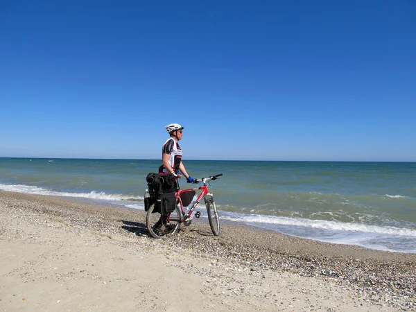 Man die op het strand met fiets. — Stockfoto