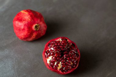 Koyu gri zemin üzerinde olgun kırmızı nar.