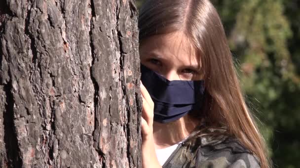 Sjuk Kid bär skyddande mask på grund av Coronavirus pandemi, Sad Girl isolerad i Park, uttråkad olycklig tonåring flicka inte spelar — Stockvideo
