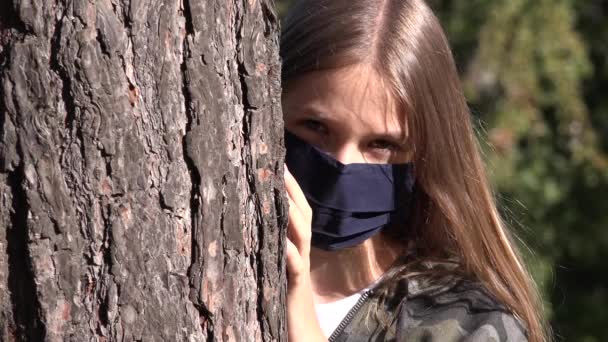 Niño enfermo usando máscara protectora debido a la pandemia del coronavirus, triste chica aislada en el parque, aburrida adolescente infeliz que no juega — Vídeo de stock