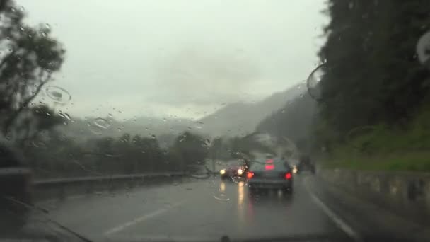 Forgalom esőben a városban, Vezető autó, Erős vihar az úton, Autópálya, Esőcseppek a szélvédőn — Stock videók
