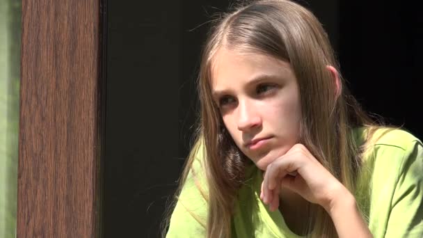 Szomorú lány néz az ablakon, boldogtalan gyermek, unalmas gondolkodó gyerek, tinédzser arc, elszigetelt emberek otthon Coronavirus krízisek — Stock videók