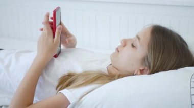Çocuk Yatakta Akıllı Telefon Oynuyor, Genç Çocuk İnternet Tarıyor, Çevrimiçi Akıllı Telefon Cihazı Alışverişi, Kız Evde Alet Kullanıyor