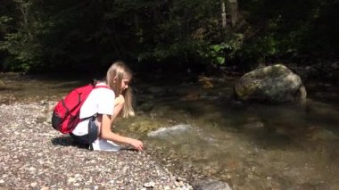 Child Playing at Mountain River at Camping, Tourist Girl Throwing Stones in Stream Water, Kid Outdoor in Trip, Children in Nature