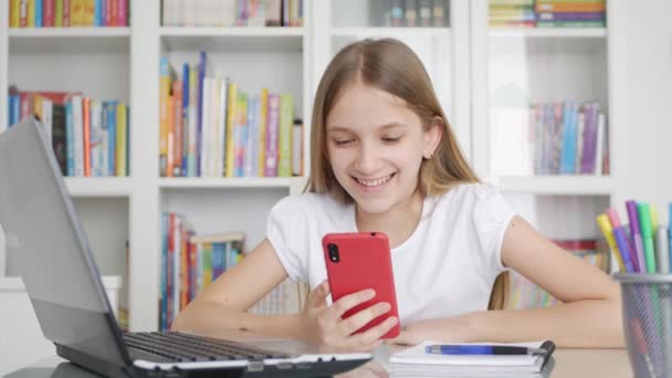 Дитина за допомогою смартфона, ноутбука, дитини, що вивчає Інтернет на настільному комп'ютері, написання дівчат-підлітків, онлайн-освіта — стокове відео