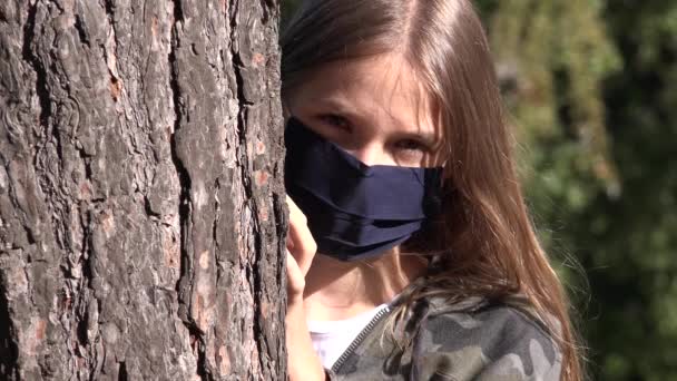 Ziek kind dragen beschermende masker als gevolg van coronavirus pandemie, verdrietig meisje geïsoleerd in het park, verveeld ongelukkige tiener Kid niet spelen — Stockvideo