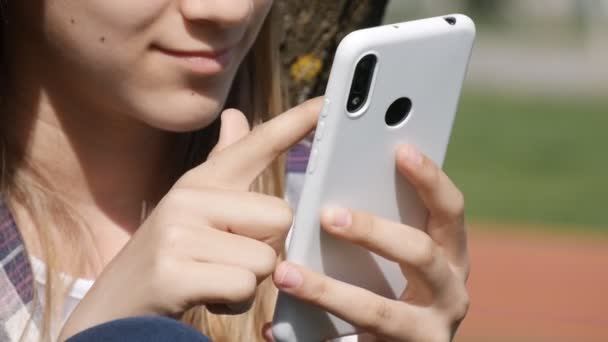 Mladá dívka hraje Smartphone, Dospívající Kid Browsing Internet na chytrém telefonu v parku, Teenager Dětské použití zařízení Venkovní příroda — Stock video