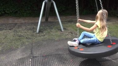Çocuk dışarıda sallanıyor, çocuk oyun bahçesinde dönüyor, sırıtan sarışın kız parkta oynuyor, doğada mutlu çocuklar var.
