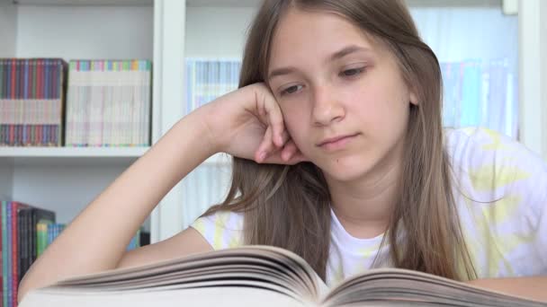 Schülerin liest Buch, Kind lernt in der Schulbibliothek, Kind im Teenageralter, Teenager lernt im Klassenzimmer, Kinder lernen — Stockvideo