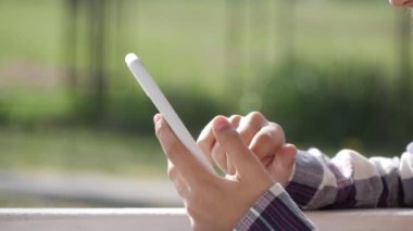 Genç kız akıllı telefondan internete bakıyor, ergen kız akıllı telefon oynuyor, ergen çocuk açık hava cihazları kullanıyor.