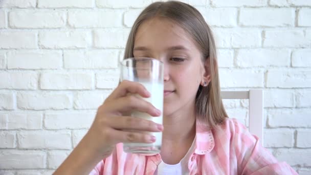 Dziecko pijące mleko przy śniadaniu, Młoda dziewczyna w kuchni, Młodzieńcze dziecko pije mleko w domu, zdrowa żywność, opieka zdrowotna — Wideo stockowe