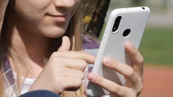 Menina adolescente jogando Smartphone, Kid navegando na Internet no telefone inteligente no parque, Dispositivos de uso de crianças adolescentes ao ar livre no parque infantil — Vídeo de Stock