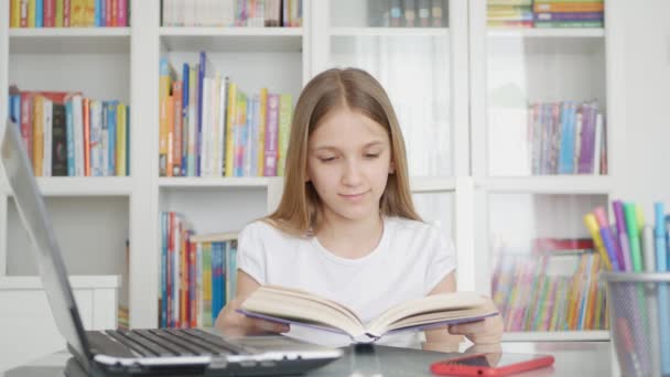 Kind liest ein Buch, Kind lernt für die Hausaufgabenschule, Schülerin lernt von zu Hause aus in Coronavirus-Pandemie, Online-Bildung — Stockvideo