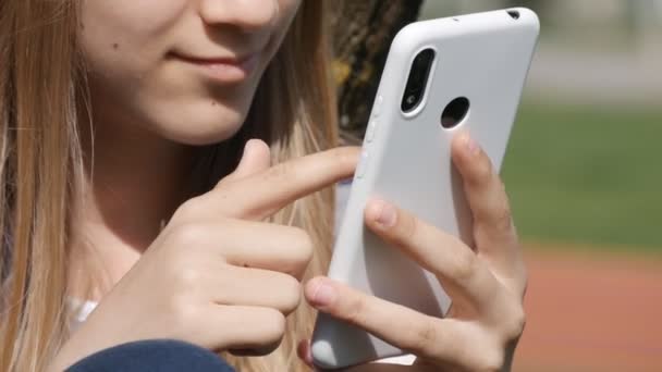 Teenager Kid Browsing Internet na chytrém telefonu v parku, Dospívající dívka hraje Smartphone Dětské použití zařízení venkovní na hřišti — Stock video