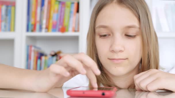 Okostelefon használata Tanulás Böngészés Internet, Fiatal lány tanulás a könyvtárban, Iskoláslány Teenager Children Online Education — Stock videók
