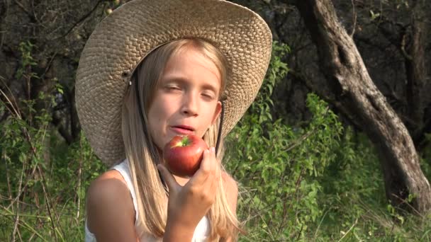 Kind isst Apfel, Mädchen im Obstgarten, Kind verkostet Früchte im Baum, Bauernmädchen auf dem Land — Stockvideo