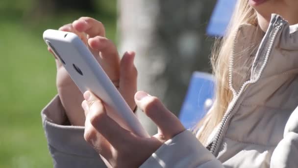 Adolescente naviguant sur Internet sur un téléphone intelligent dans le parc, Jeune enfant jouant au téléphone intelligent, Appareils d'utilisation pour enfants pour adolescents Extérieur — Video