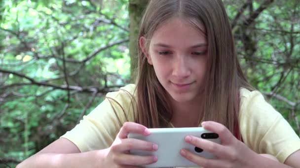 Fille naviguant sur Internet sur Smartphone en Camping, Enfant jouant au téléphone intelligent dans la forêt, Enfant sur les sentiers de montagne, Les gens en ligne — Video
