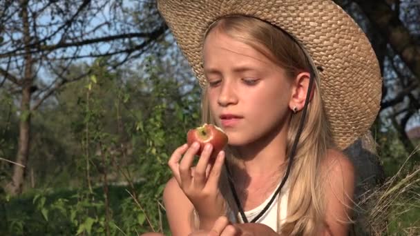 Dziewczyna jedząca jabłko, Dziecko w sadzie, Dziecko degustujące owoce w drzewie, Rolnik Blondynka z wioski na wsi — Wideo stockowe