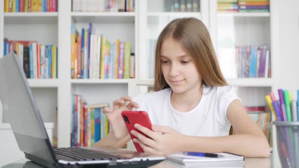 Criança usando Smartphone, Laptop, Criança estudando navegando na Internet no computador desktop, Escrita de menina adolescente, Educação escolar on-line — Vídeo de Stock