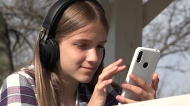 Teenager Child Playing Smartphone in Park, Adolescent Girl Browsing Internet Young Kid Listening Music on Headphones Smart Phone