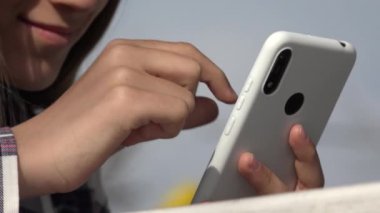 Genç kız akıllı telefondan internete bakıyor, ergen kız akıllı telefon oynuyor, ergen çocuk açık hava cihazları kullanıyor.