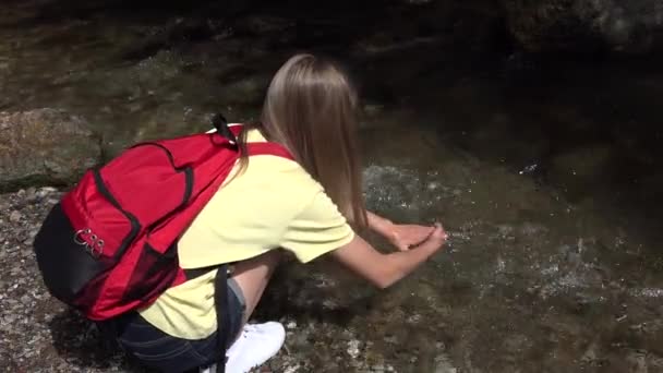 川の水で手を洗う女の子 春の滝で遊ぶ子供 山でのキャンプでの観光子供のハイキング — ストック動画