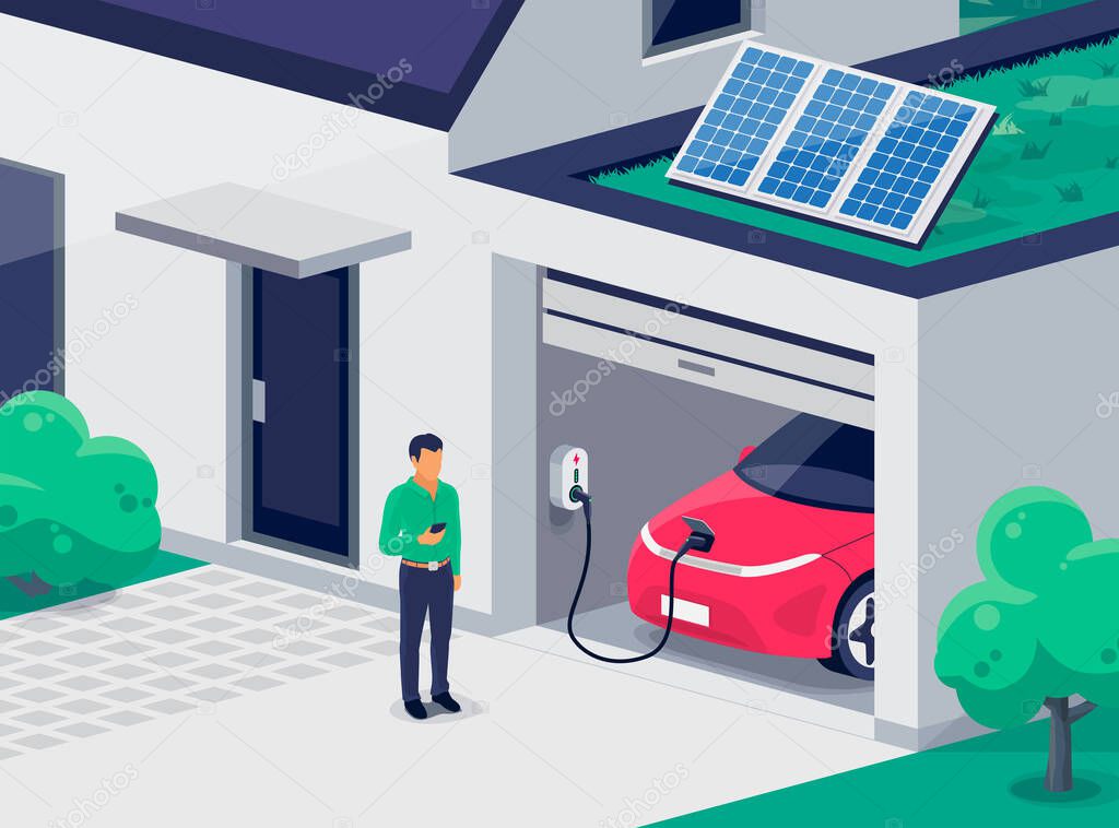 Electric car parking charging inside home garage and green roof wall box charger station. Man standing with smartphone near family house building with clean renewable energy photovoltaic solar panels.