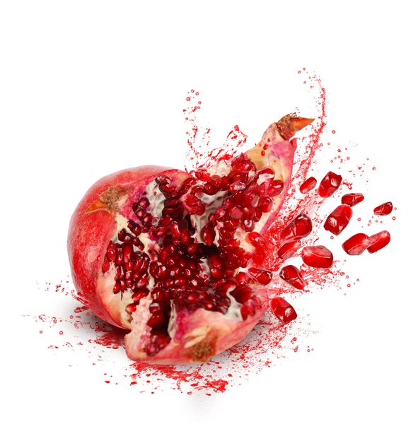 Falling and crack pomegranate with splashes of juice and seeds — Stock Photo, Image