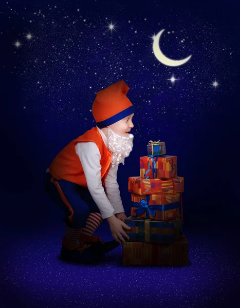 Surprised little gnome with christmas gift at the night — Stock Photo, Image