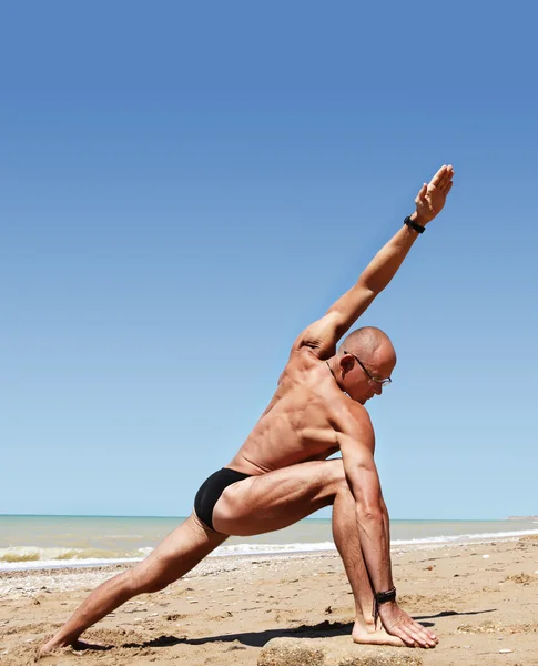 Athletic build young man doing wide angle yoga pose — Stock Photo, Image