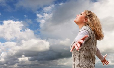 mutlu genç kadın mavi bulutlu gökyüzü görünümü