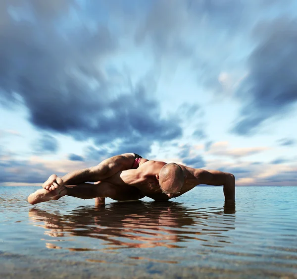 Hombre musculoso haciendo ejercicio de yoga de ocho arcos — Foto de Stock