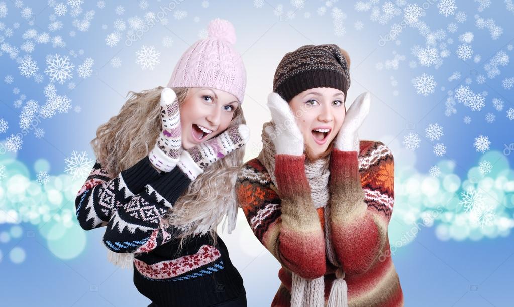 Two pretty laughing surprised girls in winter clothes